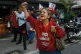 A woman in the shirt of the ruling PSUV party protests over 