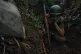 A Ukrainian soldier shelters in a trench on the frontline in