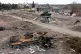 A modern Russian tank lays in ruins in front of a monument t