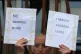 An objector to assisted suicide holds up placards outside th