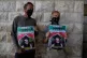 Two fellow international solidarity activists carry posters 