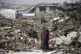 A family in their encampment in the ruins of their home amid