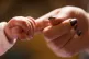 A new baby holding the finger of its mother