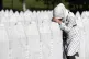 A woman leans on a gravestone in Potocari, near Srebrenica, 