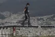 A youth balances on the railing of a popular site to overloo