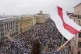 A woman waves an old Belarusian national flag standing on th