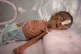 A malnourished newborn baby lies in an incubator at the Al-S