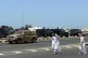 People walk near riot police cars in Sohar, Oman, Tuesday, M