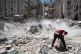 Heavy construction equipment is used to sift through rubble 