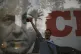 A man celebrates in front of a poster showing former Israeli