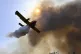 An aircraft drops water during a wildfire near Olympia town,