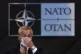 Nato secretary-general Jens Stoltenberg adjusts his face mas