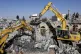 People inspect the wreckage of buildings that were damaged b