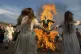 Demonstrators dance around a burning effigy of the Russian P