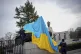 Police officers remove the flag of Ukraine from a historical
