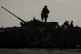 A Ukrainian soldier walks on a destroyed Russian fighting ve