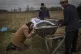 Nadiya Trubchaninova, 70, cries while holding the coffin of 