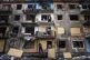Local residents close the windows of an apartment building w