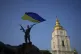 A woman brandishes the Ukrainian flag on top of a destroyed 