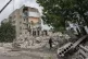 Rescue workers stand on the rubble at the scene in the after