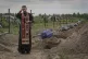 A priest prays for unidentified civilians killed by Russian 