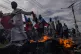 Protesters walk past a burning barricade during a protest ag
