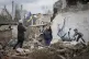 Women take a picture with an artwork on a building destroyed
