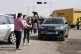 People gather at a checkpoint along a road leading to the si