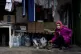 A girl pets her cat in the yard of her house in Bohoyavlenka