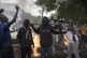 Demonstrators stand next to a barricade set on fire during a