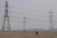 A farmer tills his land under power lines near central China