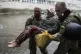 Ukrainian servicemen help rush to safety an injured civilian