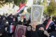 Protesters raise copies of the Quran in Baghdad, Iraq, durin