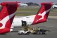 Baggage handlers work near a Qantas plane at Sydney's domest