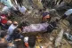 Palestinians carry a body of a dead person found under the r