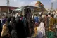 Afghan families board a bus to depart for their homeland, in