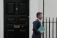 Tory Chancellor Jeremy Hunt walks to his car holding the Aut
