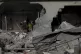 Palestinians in the ruins of their home destroyed by Israeli