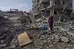 Palestinians inspect the rubble of a building of the Al Nawa