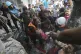 Palestinians rescue a child from under the rubble after Isra