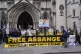 Demonstrators hold banners outside the Royal Courts of Justi