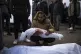 A man holds the body of his daughter who was killed by the I