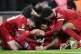 Liverpool's Virgil van Dijk celebrates, surrounded by team m