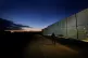 A man walks by the fence at the Pournara migrant reception c