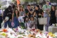 People place flowers as a tribute near a crime scene at Bond