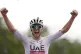 Tadej Pogačar celebrates as he cycles to the finish line to