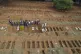 Relatives attend a burial service of a person who died from 