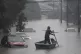 A man rows a boat on a street flooded by heavy rains, in Sao