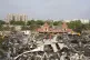 Earthmovers remove burnt debris the day after a fire broke o