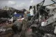 Displaced Palestinians inspect their tents destroyed by Isra